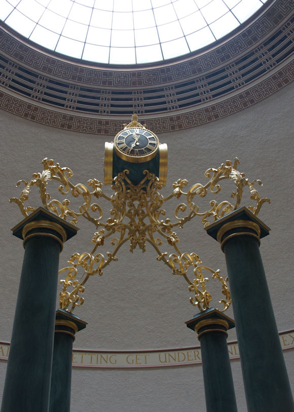 Gilded ironwork, clock and malachite coloured scagliola columns in Manchester Central Library