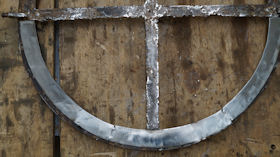 Circular iron window reconstructed with new metal sections